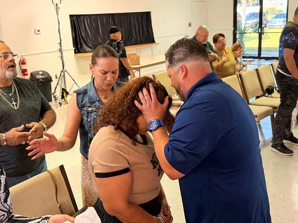 Man in blue shirt comforting emotional woman at community event in gymnasium